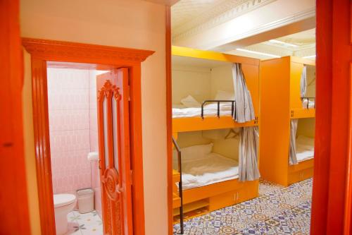 um quarto com beliches amarelos numa casa de banho em 浪子小栈Kashgar Ancient City em Kashgar