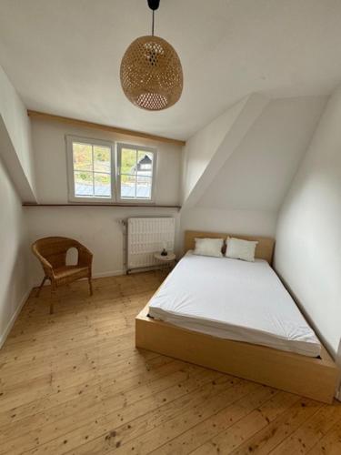 een slaapkamer met een bed en een stoel erin bij Petit-Vinave in Malmedy
