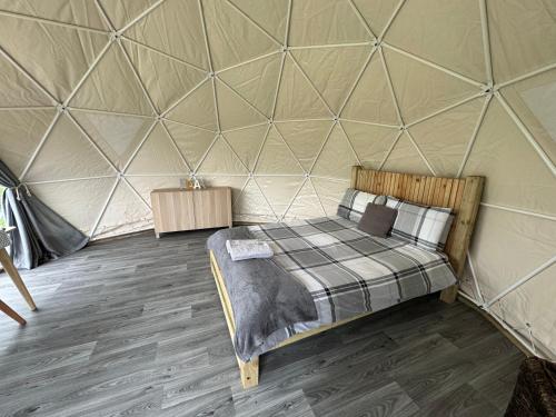 um quarto com uma cama numa tenda em Beavers Retreat Glamping em Tenby