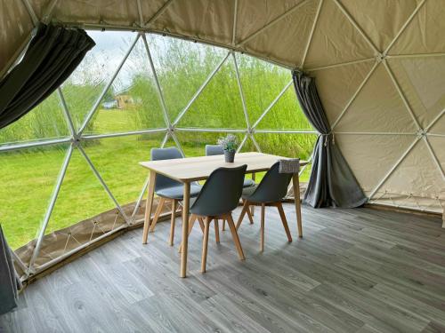 a table and chairs in a large tent at Beavers Retreat Glamping in Tenby