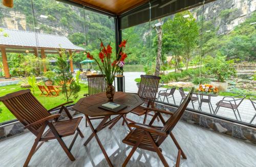 a wooden table and chairs on a patio at Hoang Minh Mountainside Villa in Ninh Binh