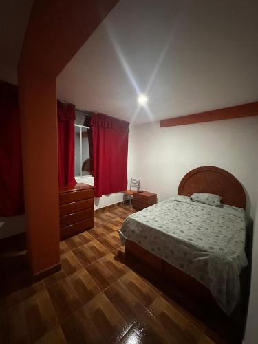 欽博特的住宿－HOSTAL VICTTORIA PRINCESS，一间卧室配有床和红色窗帘