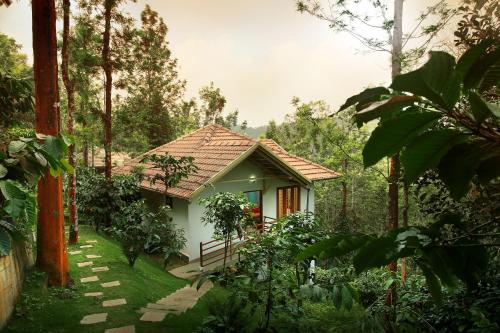 a small house in the middle of a forest at Peter's Coffee Creek Wayanad Pool Resort and Spa in Wayanad