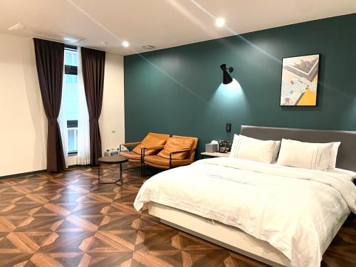 a bedroom with a large bed and a chair at Calton Hill Hotel in Jeonju