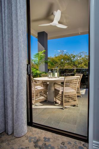 a sliding glass door to a patio with a table and chairs at The Arbour Boutique Apartments in Toowoomba