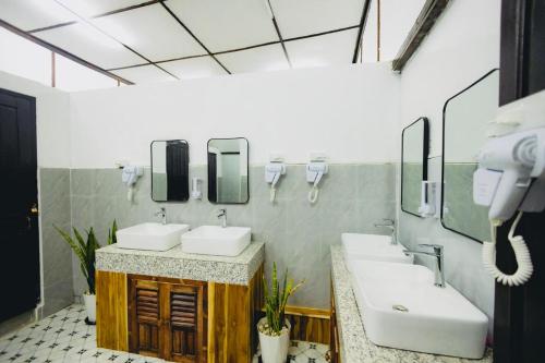 a bathroom with two sinks and two mirrors at Chanthavong Hostel in Luang Prabang