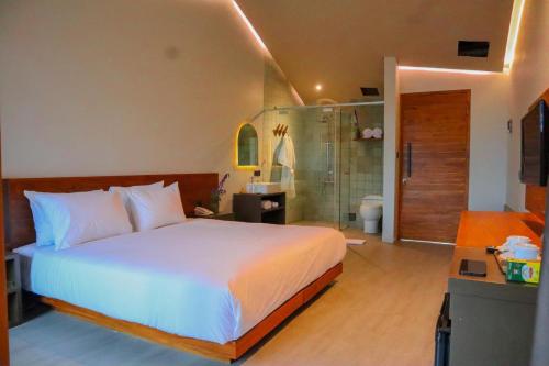 a bedroom with a bed and a bathroom with a shower at Agua Hotel in Kubupenlokan