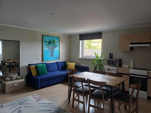 a living room with a blue couch and a table at Liisu Külalistemaja in Haapsalu