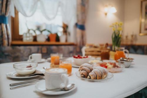 a table topped with plates of food and orange juice at Residence Obermoarhof - Family Apartments with Pool & Playground in Vandoies