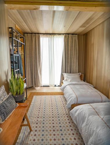 a bedroom with two beds and a large window at Elephant lodge in Kwa Kuchinia