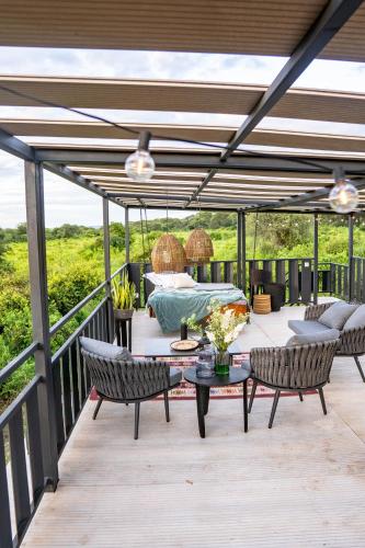 a patio with two chairs and a table on a deck at Elephant lodge in Kwa Kuchinia