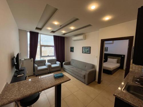 uma sala de estar com um sofá e uma televisão e uma sala de estar em 7 Days Hotel em Umm Uthainah