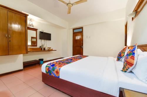 Marmagao的住宿－FabHotel Maharaja，卧室配有白色的床和电视