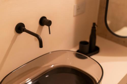 a bathroom with a sink with a faucet at Naiira Luxury Trullo - jacuzzi and patio in Alberobello