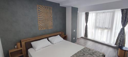 a bedroom with a white bed and a window at Olimp Family - Olimp Sea View Apartments in Olimp