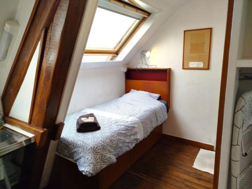 une petite chambre avec un lit et une fenêtre dans l'établissement Studette Vesle 3, à Reims