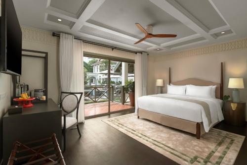 a bedroom with a bed and a ceiling fan at Souphattra Heritage Vientiane in Vientiane