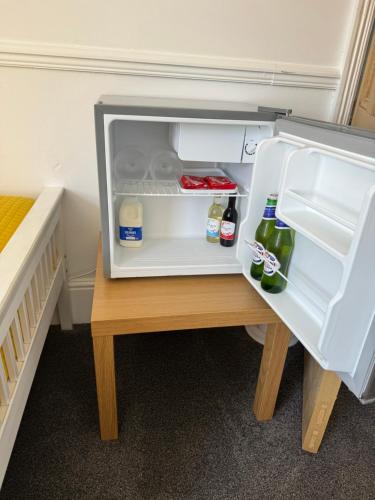 a refrigerator door is open on a wooden table at Pierremont En-Suite Rooms in Broadstairs