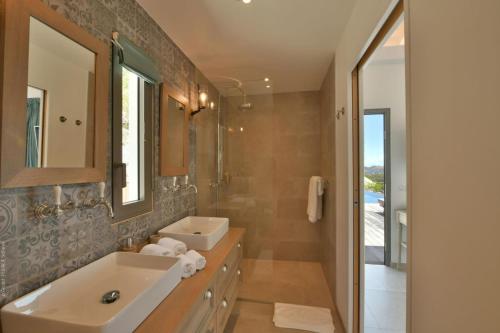 La salle de bains est pourvue d'un lavabo et d'un miroir. dans l'établissement Villa Vogue 5 Bedroom Villa, à Saint Barthelemy