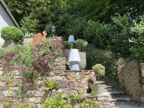 a garden with flowers and plants on a stone wall at Design and art Comfortable holiday residence in Schlangenbad