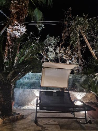 a chair in a garden with a palm tree at Villa OLD FISHERMAN'S in Taranto