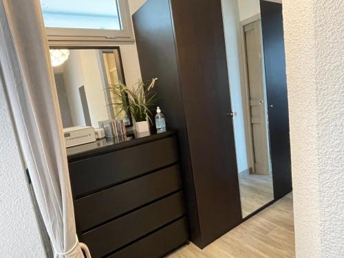 - un miroir à côté d'une commode dans une pièce dans l'établissement Les jardins du couchant, à La Grande Motte