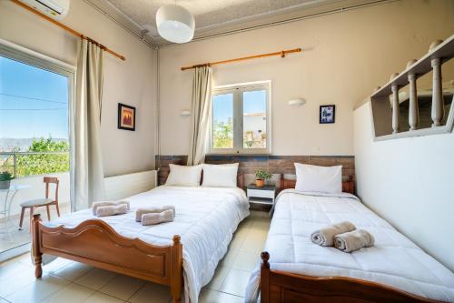 two beds in a room with a balcony at Bikakis Family Apartments in Kissamos