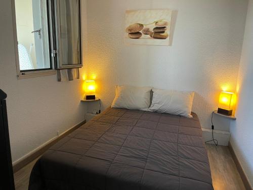 - une chambre dotée d'un lit avec deux lumières dans l'établissement Les jardins du couchant, à La Grande Motte