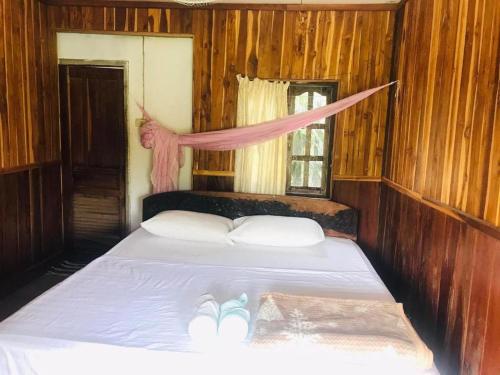 1 dormitorio con 1 cama en una habitación de madera en The Smiling Lao, en Muang Không