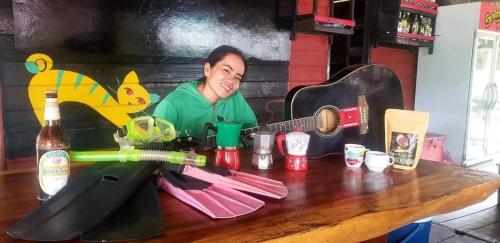 una mujer sentada en una mesa con una guitarra en The Smiling Lao, en Muang Không