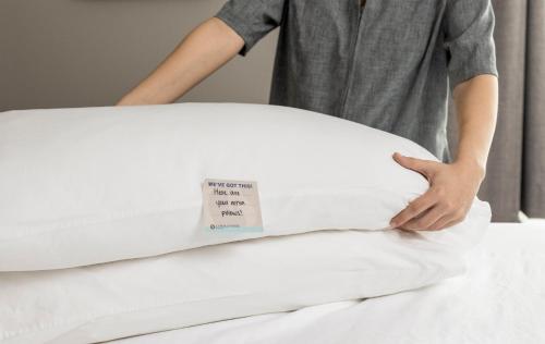 a man is placing a mattress on a bed at Candlewood Suites Burlington by IHG in Burlington