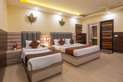 um quarto de hotel com duas camas num quarto em Hotel New Darbar House em Nova Deli