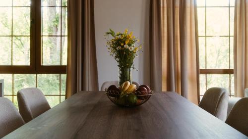 a table with a bowl of fruit and a vase of flowers at Eko Zaseok Brana in Rekovac