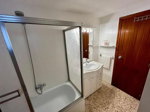 a bathroom with a tub and a sink and a shower at Apartamento OLIVA PLAYA - PAU PI in Oliva