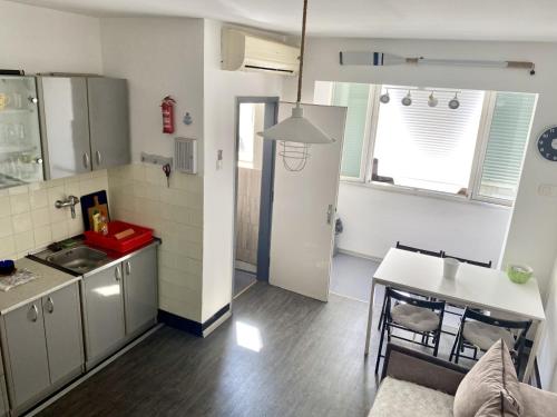 - une cuisine avec un évier et une table dans une chambre dans l'établissement Apartment Riva, à Tivat