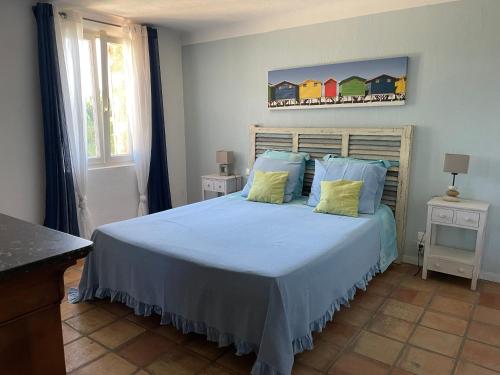 une chambre avec un grand lit avec des oreillers bleus dans l'établissement Villa Eden, à Tourrettes-sur-Loup