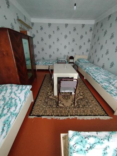 um quarto com duas camas e uma mesa em Hostel ucuz em Lankaran