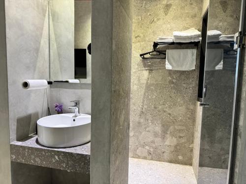 a bathroom with a white sink and a mirror at Flowering Villa in Xiaoliuqiu