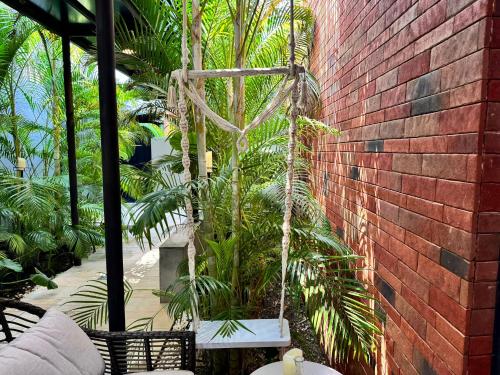 a palm tree swing hanging from a brick wall at Flowering Villa in Xiaoliuqiu