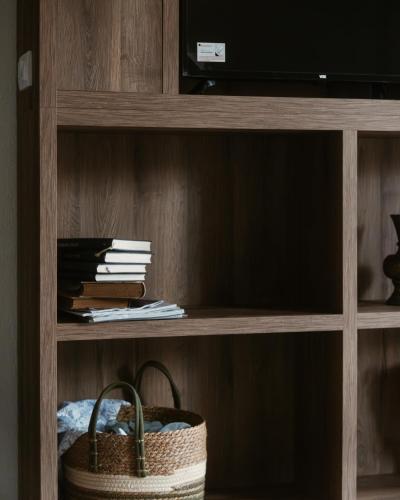 a book shelf with a basket and a television at Eko Zaseok Brana in Rekovac