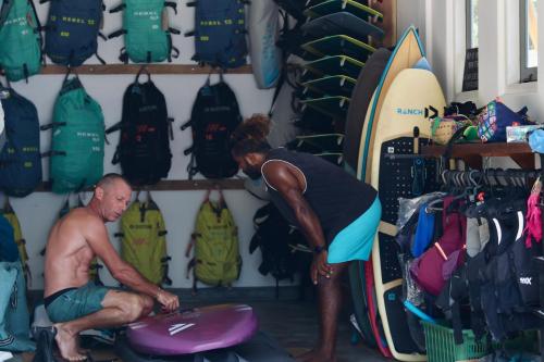 a man and a woman looking at surfboards in a store at The Rascals Kite Resort in Kalpitiya