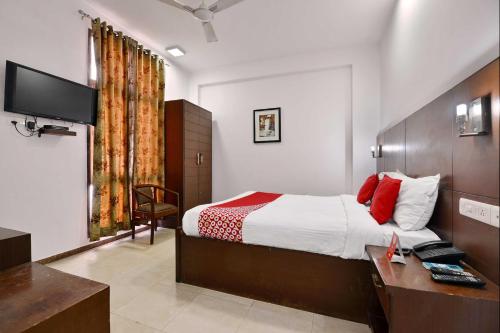 um quarto com uma cama, uma secretária e uma televisão em Super OYO Jaipur Casa Near Sawai Man Singh Stadium em Jaipur
