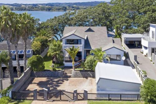 an aerial view of a house with palm trees at Seaside Serenity 4BR Modern Home in Auckland