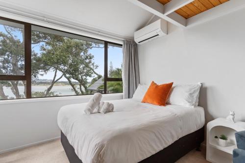 a bedroom with a bed with two stuffed animals on it at Seaside Serenity 4BR Modern Home in Auckland