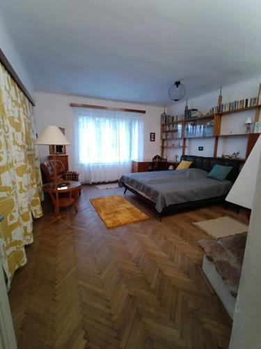 a bedroom with a large bed and a wooden floor at Garden Apartman Malvazinky in Prague