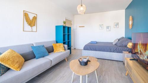 un salon avec un canapé et un lit dans l'établissement Bleu Paon - Welc'Home, à Limoges