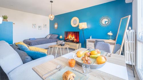 un salon bleu avec une table avec un bol de fruits dans l'établissement Bleu Paon - Welc'Home, à Limoges
