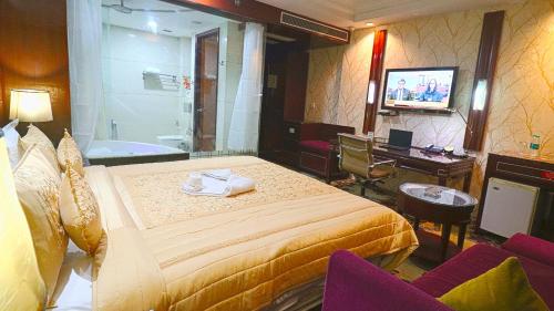 a hotel room with a bed and a tub and a television at SkyCity Hotel Gurgaon in Gurgaon