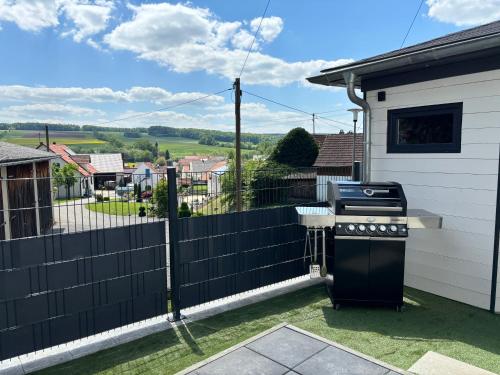 a backyard with a black fence and a grill at Ferienwohnung im Usseltal - Zirben Spa - Monheimer Alb - Altmühltal - Familie Geyer Daiting in Monheim