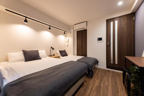 a hotel room with two beds and a window at Sanctuary Residence難波大国Ⅱ in Osaka